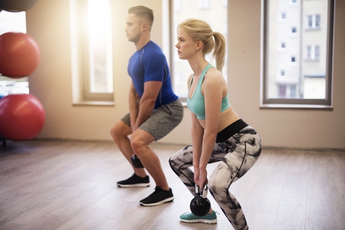 Couple focused on workout with kettles