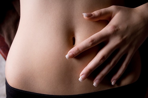 Woman touching bare stomach